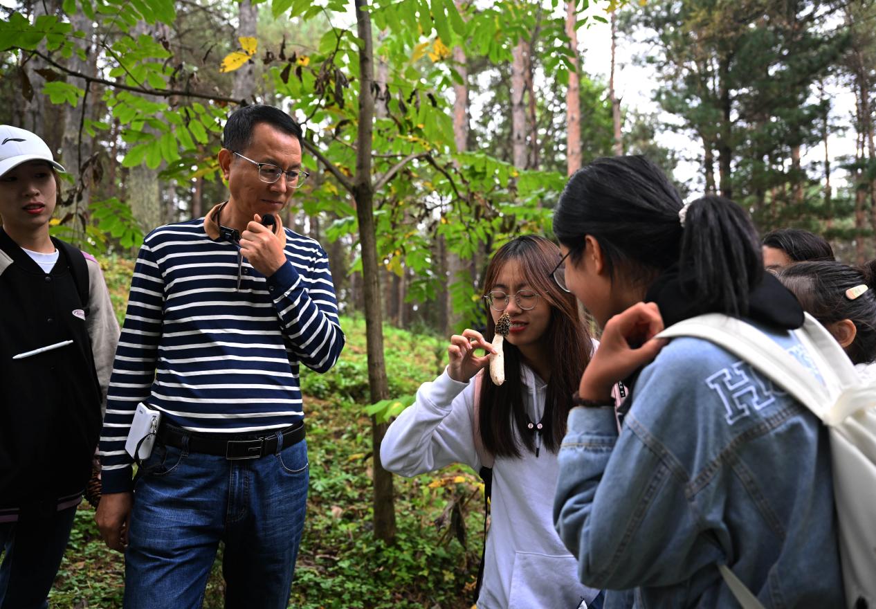 王占斌老師給同學(xué)們講解辨識(shí)蘑菇。（學(xué)校供圖）.jpg