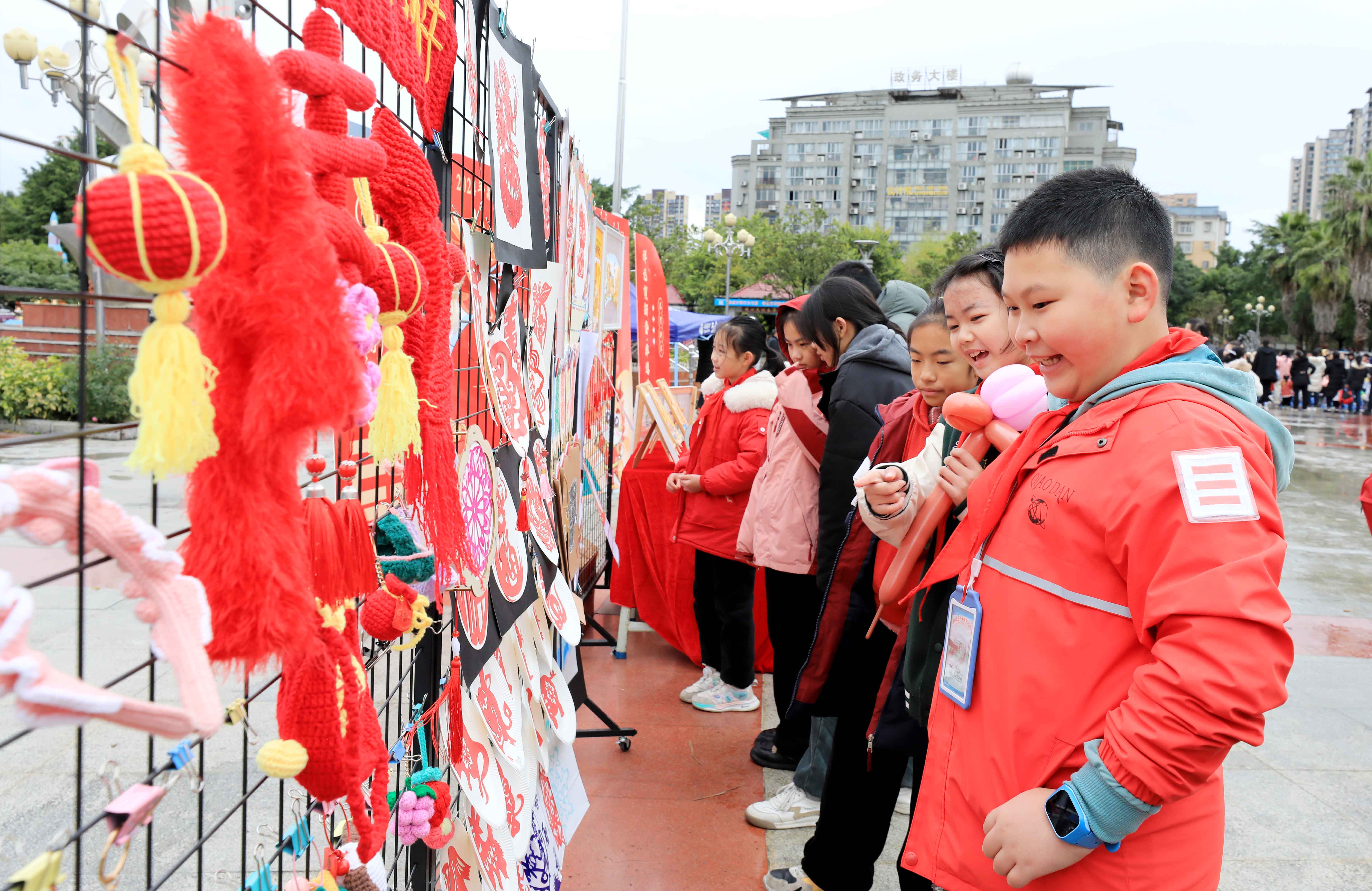 圖7：1月20日，在廣西柳州市融安縣長(zhǎng)安廣場(chǎng)，學(xué)生在非遺集市上選購作品。（譚凱興 攝）.JPG